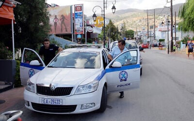 Illustrative: Policemen enter their vehicle on July 23, 2013, in Malia on the Greek island of Crete. (AFP/Costas Metaxakis)