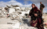 A Palestinian woman reacts as she holds the dust from the rubble of her house which was demolished by Israeli security forces, in the Palestinian village of Beit Awwa in the southwest of the West Bank on February 11, 2026. (HAZEM BADER/AFP)