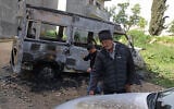 Illustrative: A Palestinian man inspects a burnt car following a reported attack by Israeli settlers in Jalud village, south of Nablus in the West Bank, on March 22, 2026. (JAAFAR ASHTIYEH/AFP)