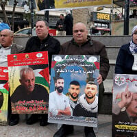Demonstrators gather with placards bearing portraits of Palestinians currently detained by Israel, during a protest in solidarity with them in the West Bank city of Ramallah on April 7, 2026. (Photo by Zain JAAFAR / AFP)