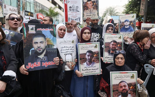 Palestinian demonstrators hold pictures jailed Palestinians during a rally in Ramallah in the West Bank on April 19, 2026, to mark Prisoners' Day and to protest against the Knesset's approval of a new death penalty bill for Palestinians convicted of deadly attacks. (JAAFAR ASHTIYEH / AFP)
