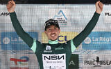 NSN Cycling Team's Israeli rider Nadav Raisberg celebrates on the podium with the sprinter's green jersey after the 8th and final stage of the Tour Auvergne-Rhone-Alpes cycling race in the French Alps on June 14, 2026. (Anne-Christine POUJOULAT / AFP)