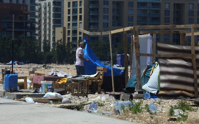 A man stands next to a dismantled tent at the displaced families' camp along the waterfront area in Beirut on July 1, 2026. (AFP) A man stands next to a dismantled tent at the displaced families' camp along the waterfront area in Beirut on July 1, 2026. (AFP)