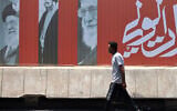 A commuter walks past a billboard bearing pictures of Iran's late supreme leader Ayatollah Ali Khamenei, along a street in Baghdad on July 2, 2026, ahead of his funeral in Tehran. (AHMAD AL-RUBAYE / AFP)