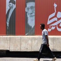A commuter walks past a billboard bearing pictures of Iran's late supreme leader Ayatollah Ali Khamenei, along a street in Baghdad on July 2, 2026, ahead of his funeral in Tehran. (AHMAD AL-RUBAYE / AFP)