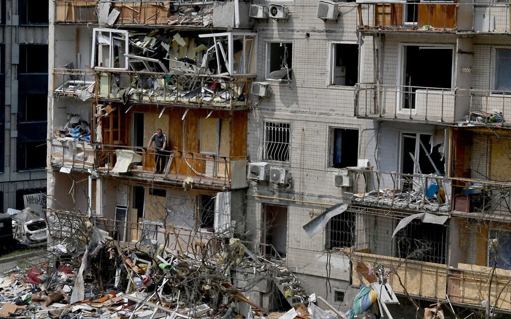A local resident stands on the balcony of his flat in a residential building damaged by a Russian air attack on the Ukrainian capital of Kyiv, on July 3, 2026. (Sergei SUPINSKY / AFP)
