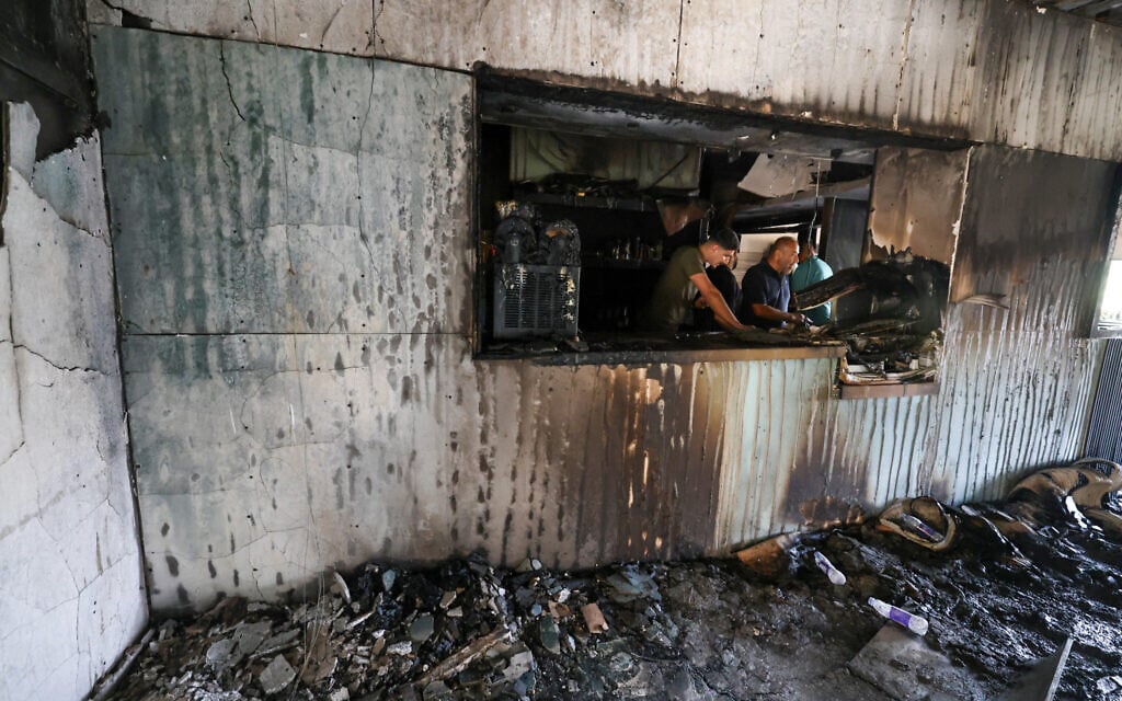 Palestinian men inspect the aftermath inside a restaurant after it was burned down by settlers during an attack in the western area of the Al-Lubban ash-Sharqiya village, south of Nablus, in the West Bank on on July 5, 2026.  (Photo by JAAFAR ASHTIYEH / AFP)