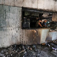 Palestinian men inspect the aftermath inside a restaurant after it was burned down by settlers during an attack in the western area of the Al-Lubban ash-Sharqiya village, south of Nablus, in the West Bank on on July 5, 2026.  (Photo by JAAFAR ASHTIYEH / AFP)