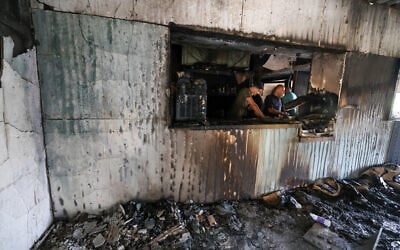 Palestinian men inspect the aftermath inside a restaurant after it was burned down by settlers during an attack in the western area of the Al-Lubban ash-Sharqiya village, south of Nablus, in the West Bank on on July 5, 2026. (Photo by JAAFAR ASHTIYEH / AFP) Palestinian men inspect the aftermath inside a restaurant after it was burned down by settlers during an attack in the western area of the Al-Lubban ash-Sharqiya village, south of Nablus, in the West Bank on on July 5, 2026. (Photo by JAAFAR ASHTIYEH / AFP)