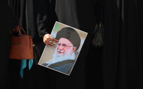 A woman holds a picture of slain Iranian supreme leader Ali Khamenei near the shrine of Imam Hussein in the Iraqi holy city of Karbala on July 8, 2026. (AHMAD AL-RUBAYE / AFP)