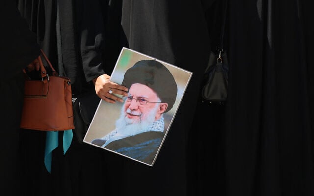 A woman holds a picture of slain Iranian supreme leader Ali Khamenei near the shrine of Imam Hussein in the Iraqi holy city of Karbala on July 8, 2026. (AHMAD AL-RUBAYE / AFP)