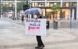 A protester stands in rain near the White House on July 28, 2026, in Washington, DC. (Finn Gomez/Getty Images/AFP)