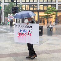 A protester stands in rain near the White House on July 28, 2026, in Washington, DC. (Finn Gomez/Getty Images/AFP)