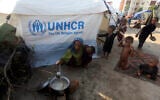 Displaced people from heavy monsoon flooding take refuge as they prepare tea at a temporary tent housing camp organized by the UN Refugee Agency (UNHCR), in Sukkur, Pakistan, September 10, 2022. (Fareed Khan/AP)