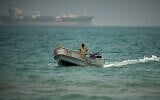 Backdropped by an LPG (liquefied petroleum gas) tanker, a Yemeni soldier sails in waters north of the Bab el-Mandeb Strait in Mokha, Yemen, April 6, 2026 (AP Photo/Abdulnasser Alseddik)