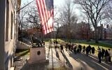 People take photos near a John Harvard statue, left, on the Harvard University campus, in Cambridge, Massachusetts, January 2, 2024. (Steven Senne/AP)