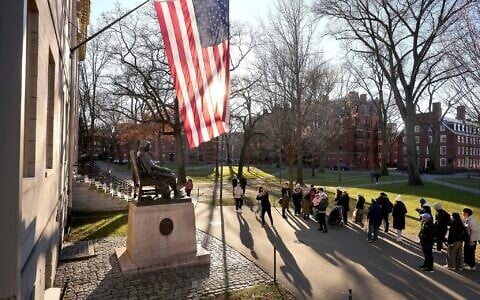 People take photos near a John Harvard statue, left, on the Harvard University campus, in Cambridge, Massachusetts, January 2, 2024. (Steven Senne/AP)