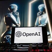 The OpenAI logo is displayed on a cellphone with an image on a computer monitor generated by ChatGPT’s Dall-E text-to-image model, December 8, 2023, in Boston. (AP Photo/Michael Dwyer)