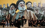 Hezbollah supporters sit in front of a giant billboard, that shows the two late leaders Hassan Nasrallah and Hashem Safieddine, center, with other Hezbollah killed commanders, as they listen to the death story of Imam Hussein during the holy day of Ashoura in Dahiyeh, Beirut’s southern suburbs, Lebanon, June 26, 2026. (AP/Hussein Malla)
