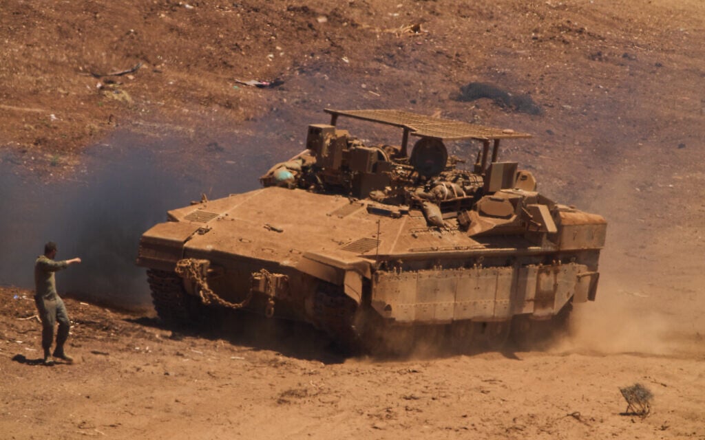 An IDF  soldier directs an APC near the border with Lebanon in northern Israel, July 1, 2026. (AP Photo/Ariel Schalit)