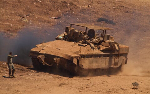 An IDF  soldier directs an APC near the border with Lebanon in northern Israel, July 1, 2026. (AP Photo/Ariel Schalit)