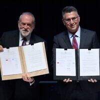 Foreign Minister Gideon Sa'ar (right) and US Ambassador to Israel Mike Huckabee present the land‑allocation agreement for the permanent US Embassy in Jerusalem to the audience during a ceremony on July 1, 2026. (AP/Ohad Zwigenberg)