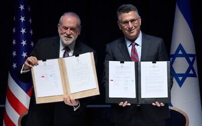 Foreign Minister Gideon Sa'ar (right) and US Ambassador to Israel Mike Huckabee present the land‑allocation agreement for the permanent US Embassy in Jerusalem to the audience during a ceremony on July 1, 2026. (AP/Ohad Zwigenberg)