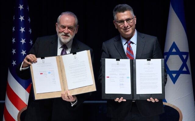 Foreign Minister Gideon Sa'ar (right) and US Ambassador to Israel Mike Huckabee present the land‑allocation agreement for the permanent US Embassy in Jerusalem to the audience during a ceremony on July 1, 2026. (AP/Ohad Zwigenberg)