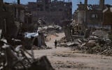 A Palestinian child walks along a street surrounded by buildings destroyed in Israeli military strikes during the Israel-Hamas war in Khan Younis, Gaza Strip, July 1, 2026. (AP Photo/Abdel Kareem Hana)