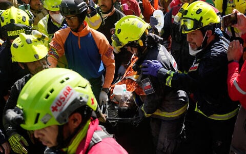 Rescue workers carry Hernán Alberto Gil Flores Gil who was pulled from the rubble eight days after he was trapped by twin earthquakes that struck Catia La Mar, Venezuela, July 2, 2026. (AP Photo/Fernando Vergara)