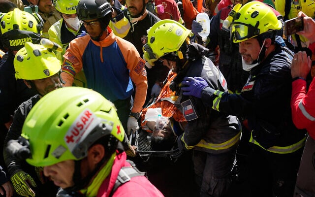 Rescue workers carry Hernán Alberto Gil Flores Gil who was pulled from the rubble eight days after he was trapped by twin earthquakes that struck Catia La Mar, Venezuela, July 2, 2026. (AP Photo/Fernando Vergara)