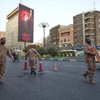 Iran's Basij paramilitary forces set up a checkpoint at a square ahead of the funeral ceremonies of slain supreme leader Ayatollah Ali Khamenei, shown at the billboard at rear, in Tehran, Iran, July 2, 2026. (AP/Vahid Salemi)