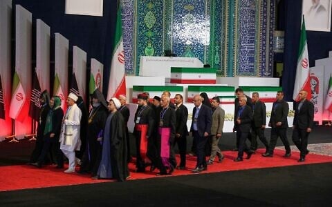 Iranian religious leaders and other mourners walk past the coffins of slain Iranian Supreme Leader Ayatollah Ali Khamenei and members of his family during a viewing ceremony ahead of the dayslong funeral ceremonies at the Imam Khomeini Mosalla Grand Mosque in Tehran, Iran, July 3, 2026. (AP Photo/Vahid Salemi)