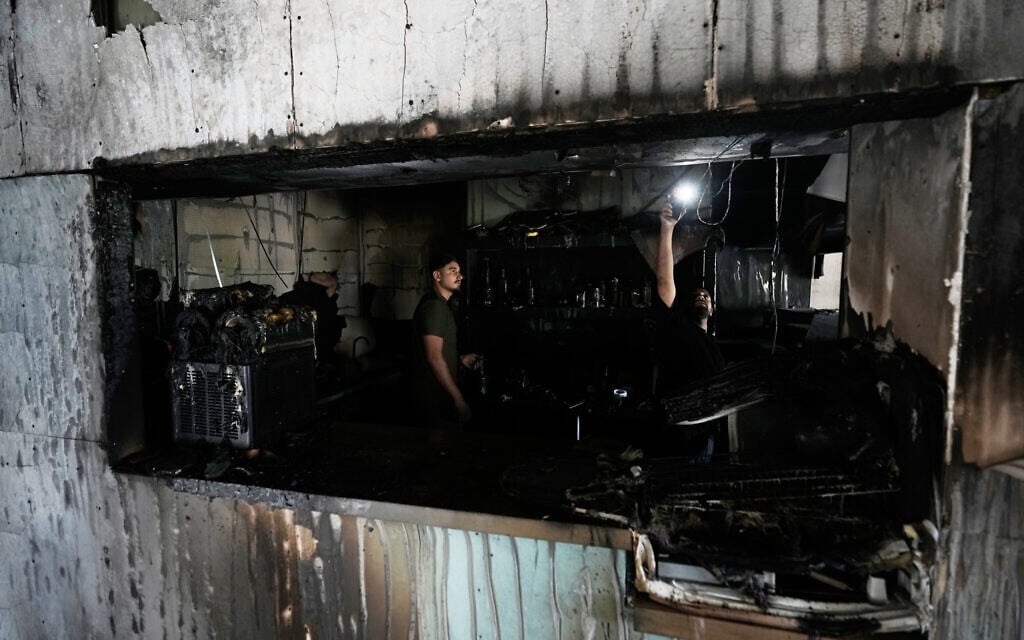 Palestinians inspect the remains of a restaurant that was set on fire overnight by Israeli settlers near the West Bank town of Salfit, July 5, 2026. (AP Photo/Majdi Mohammad)