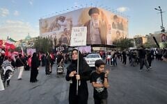 A woman holds a sign reading 'We'll Kill Trump' while waiting in Islamic Revolution Square for the funeral procession of the slain Iranian Supreme Leader Ayatollah Ali Khamenei beneath a billboard depicting Khamenei in Tehran, Iran, July 6, 2026. (Altaf Qadri/AP)