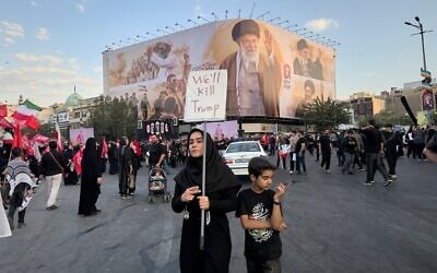 A woman holds a sign reading 'We'll Kill Trump' while waiting in Islamic Revolution Square for the funeral procession of the slain Iranian Supreme Leader Ayatollah Ali Khamenei beneath a billboard depicting Khamenei in Tehran, Iran, July 6, 2026. (Altaf Qadri/AP) A woman holds a sign reading 'We'll Kill Trump' while waiting in Islamic Revolution Square for the funeral procession of the slain Iranian Supreme Leader Ayatollah Ali Khamenei beneath a billboard depicting Khamenei in Tehran, Iran, July 6, 2026. (Altaf Qadri/AP)