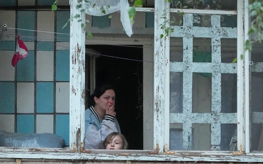 Local residents look out of the balcony at a building damaged by Russian missile attack in Kyiv, Ukraine, July 6, 2026. (AP Photo/Efrem Lukatsky)