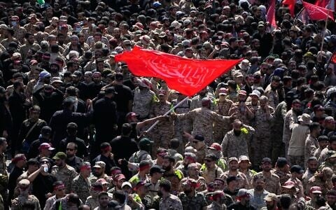 Uniformed members of the Islamic Revolutionary Guard Corps wave a Shiite religious flag during the funeral procession for Iranian supreme leader ayatollah Ali Khamenei and members of his family in Tehran, Iran, July 6, 2026. (AP Photo/Vahid Salemi)