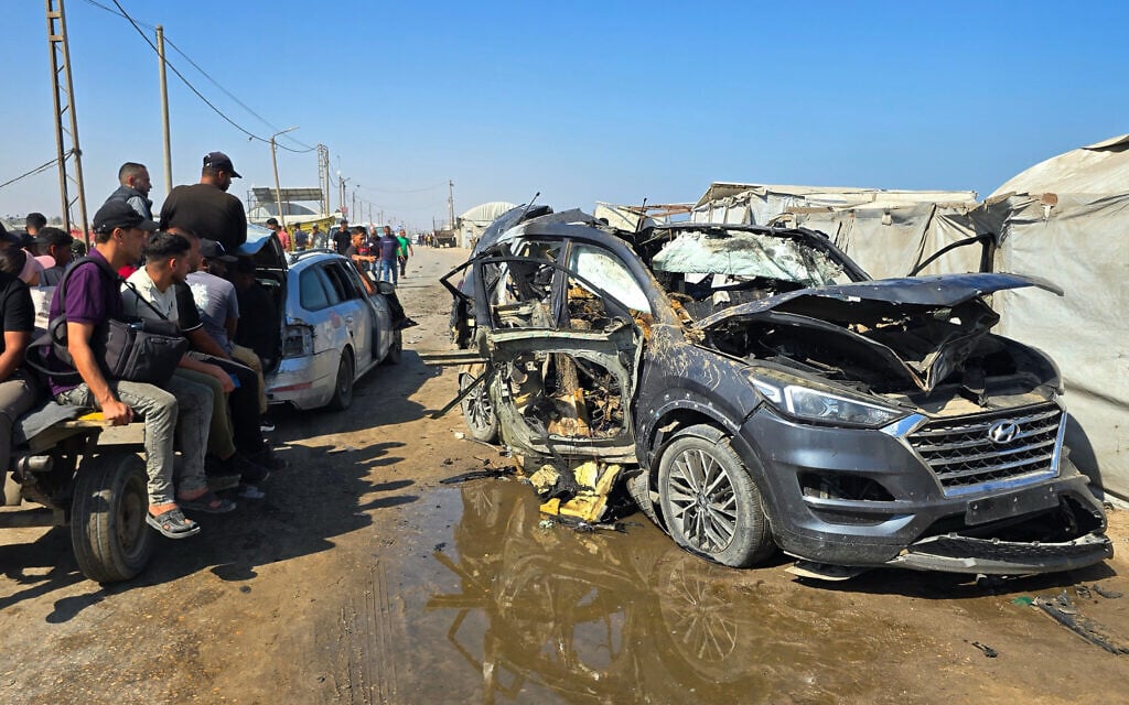 Palestinians look at a destroyed car following an Israeli military strike in Khan Younis, southern Gaza Strip, Monday, July 6, 2026 (AP Photo/Mohammad Jahjouh)