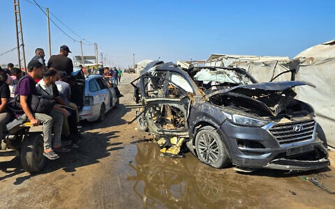 Palestinians look at a destroyed car following an Israeli military strike in Khan Younis, southern Gaza Strip, Monday, July 6, 2026 (AP Photo/Mohammad Jahjouh)