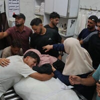 Friends and relatives mourn over the body of Omran Abu Jarad, 48, who was killed in an Israeli military strike, during his funeral at Shifa Hospital in Gaza City, July 7, 2026. (AP Photo/Abdel Kareem Hana)