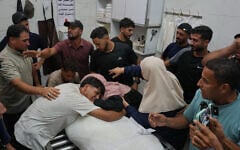 Friends and relatives mourn over the body of Omran Abu Jarad, 48, who was killed in an Israeli military strike, during his funeral at Shifa Hospital in Gaza City, July 7, 2026. (AP Photo/Abdel Kareem Hana)