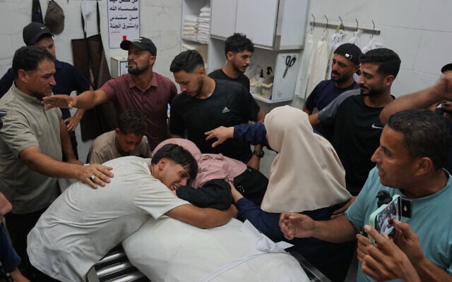 Friends and relatives mourn over the body of Omran Abu Jarad, 48, who was killed in an Israeli military strike, during his funeral at Shifa Hospital in Gaza City, July 7, 2026. (AP Photo/Abdel Kareem Hana)