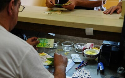 A currency exchange employee counts Israeli Shekels at a bureau in the West Bank city of Bethlehem, July 7, 2026. (AP Photo/Mahmoud Illean) A currency exchange employee counts Israeli Shekels at a bureau in the West Bank city of Bethlehem, July 7, 2026. (AP Photo/Mahmoud Illean)