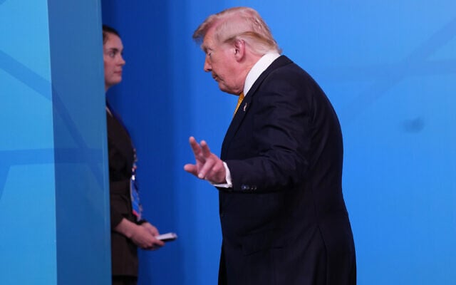US President Donald Trump walks off the podium after a group photo of NATO heads of state and government during the NATO summit in Ankara, Turkey, July 8, 2026. (AP Photo/Francisco Seco)