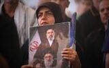 A mourner holds a portrait depicting Iran's Supreme Leader Ayatollah Mojtaba Khamenei, top, and his late father, Ayatollah Ali Khamenei, during a funeral procession for the elder Khamenei inside the Imam Ali Shrine in Najaf, Iraq, July 8, 2026. (AP/Hadi Mizban)