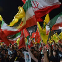 Hezbollah supporters wave Hezbollah and Iranian flags during a gathering in Beirut’s southern suburbs, Lebanon, July 8, 2026. (AP Photo/Mustafa Jamalddine)