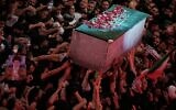 The flower petal-covered coffin of the late Iranian supreme leader ayatollah Ali Khamenei is carried above mourners reaching out to touch it outside the Imam Hussein Shrine in Karbala, Iraq, July 9, 2026. (AP/Khalil Hamra)