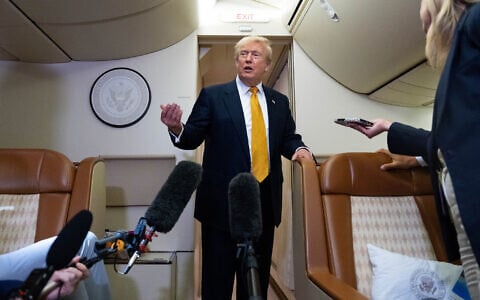 US President Donald Trump speaks with reporters in flight on Air Force One after landing at US Air Force Base at RAF Mildenhall, in Suffolk, Eastern England, July 8, 2026. (AP Photo/Alex Brandon)