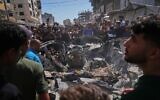 Palestinians gather around a car hit in an Israeli military strike that, according to Hamas-run health authorities, killed at least one person in Gaza City, July 9, 2026. (AP/Jehad Alshrafi)
